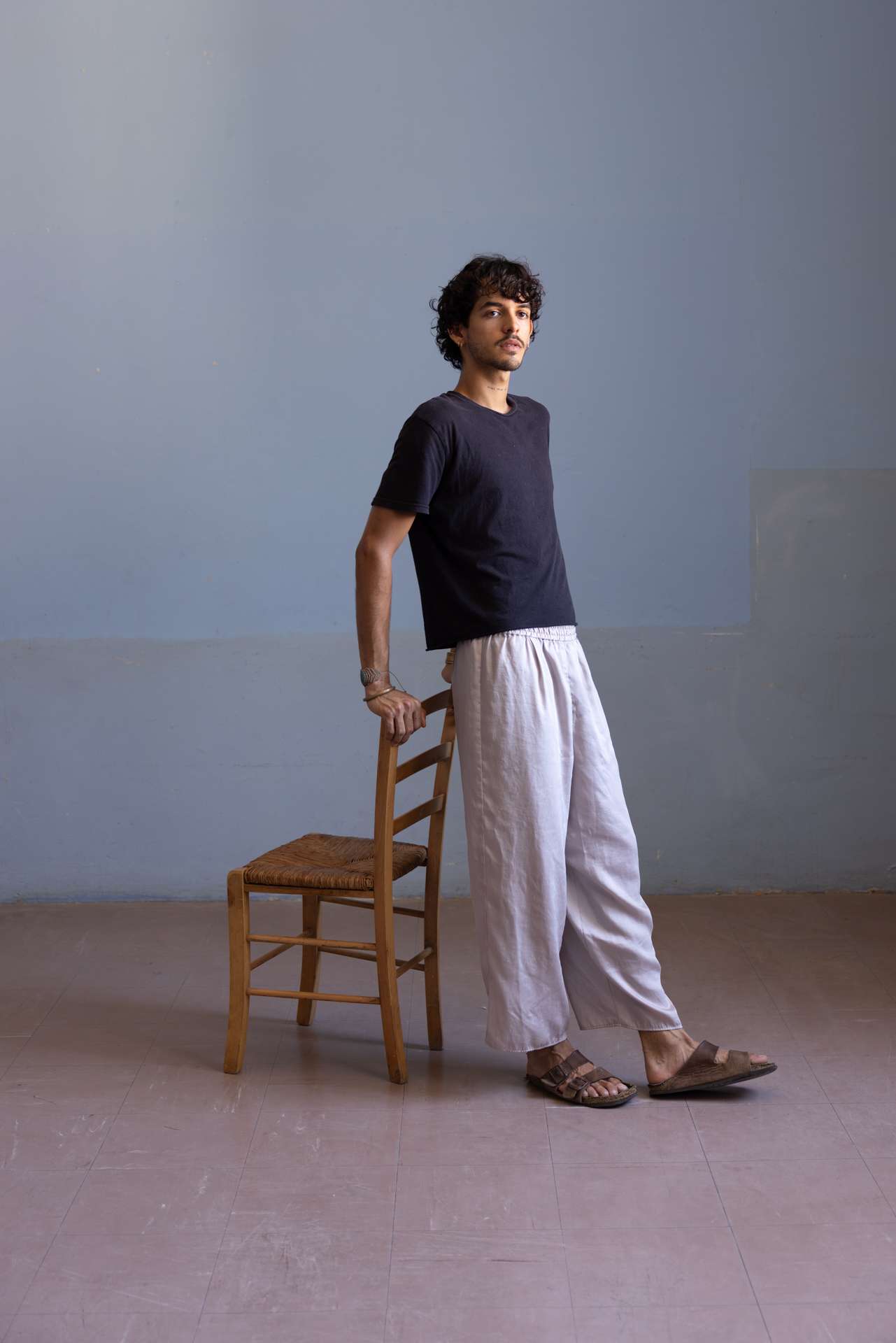 Photo d'un homme adossé à une chaise