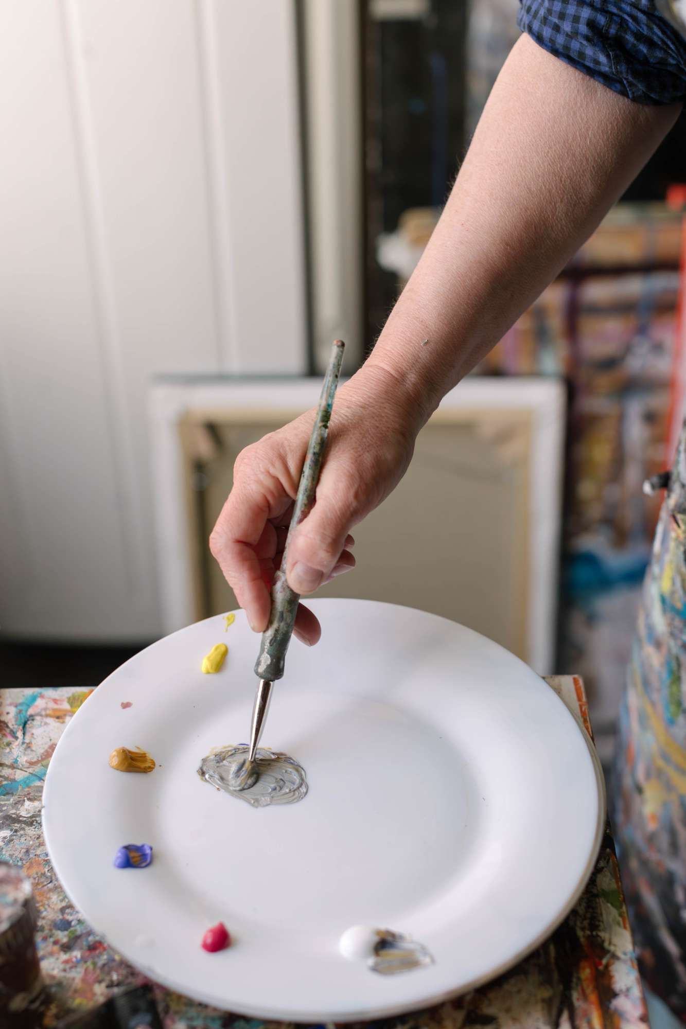 Pinceau tenue par l'artiste avec des points de couleur